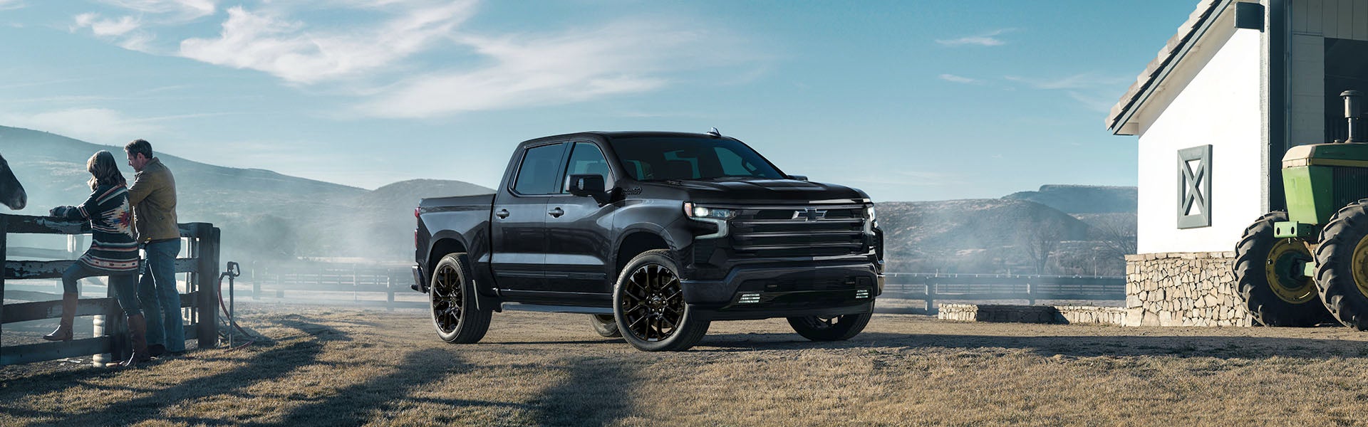 A black truck sitting parked off-road.