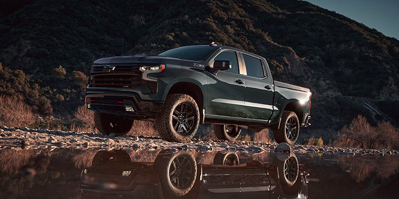 A green truck sitting parked outdoors.