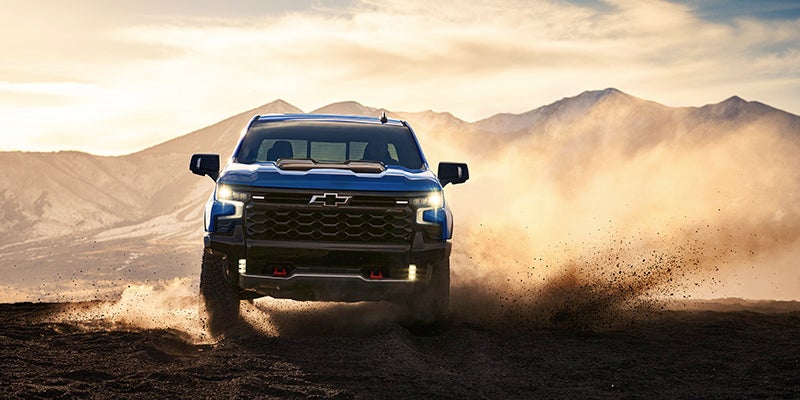 A blue truck driving off-road.