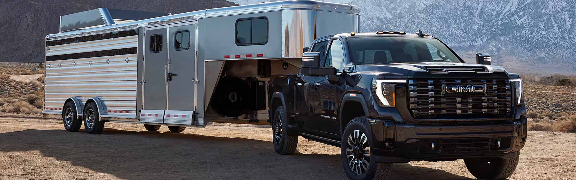 a 2025 gmc sierra hd parked with a horse trailer attached
