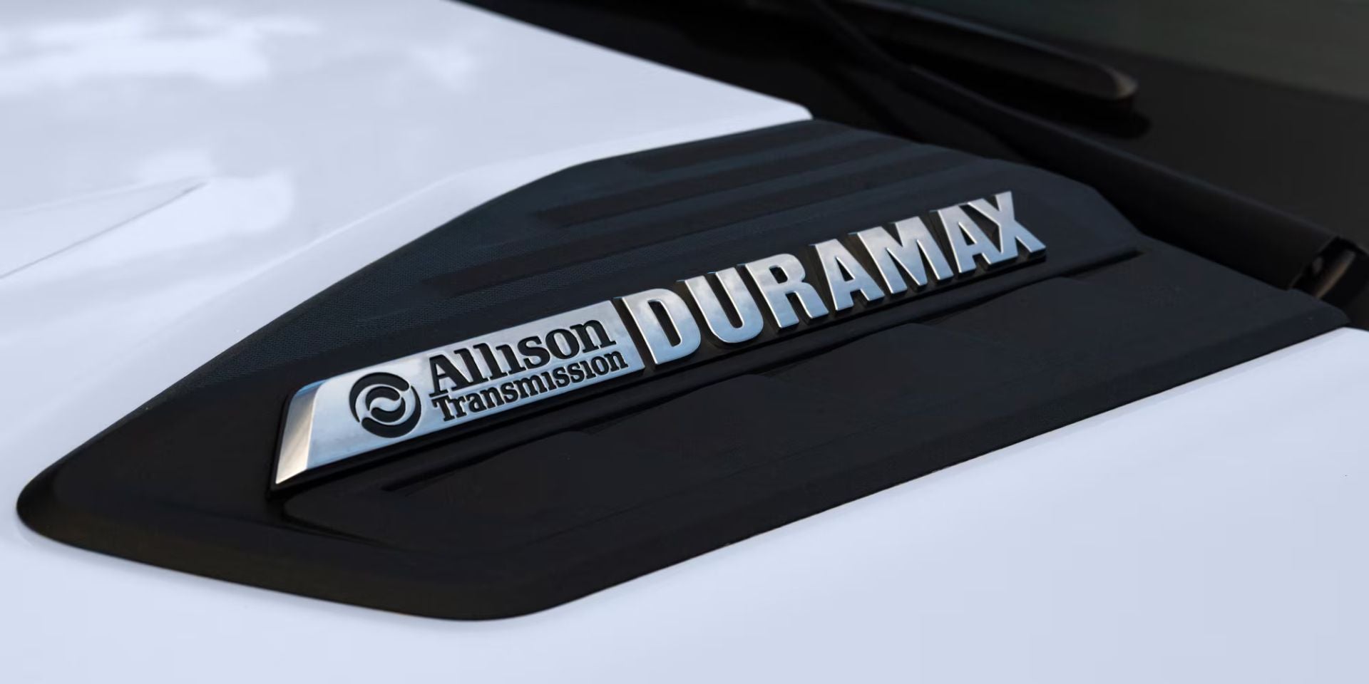 allison duramax badging on the hood of a white silverado hd