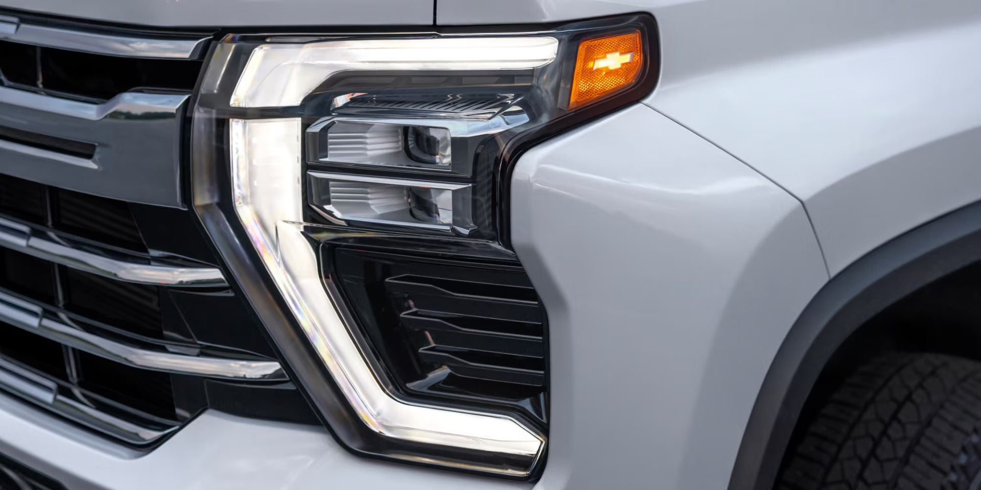 front led headlights up close on a white silverado hd