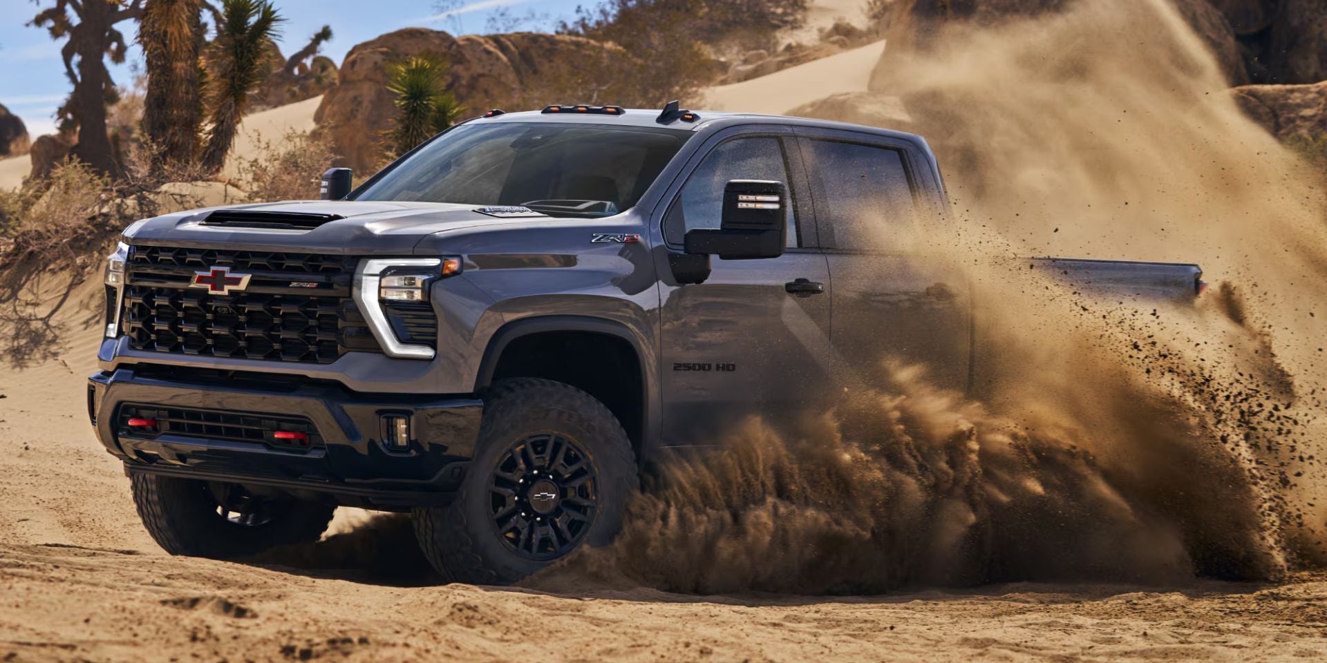a white 2025 chevy silverado 2500hd parked on dirt next to a new construction house