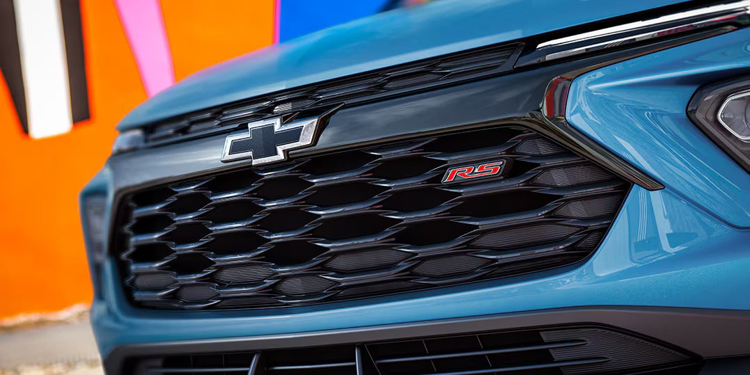 the RS badging on the front grille of a blue 2025 chevrolet trailblazer