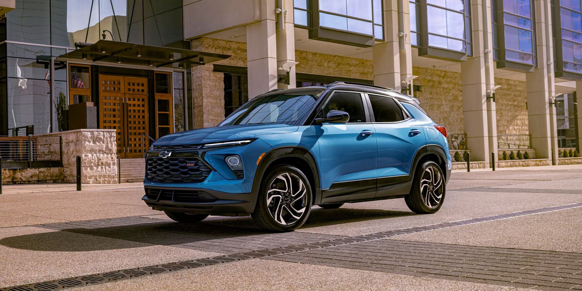 a blue chevy trailblazer parked next to a building