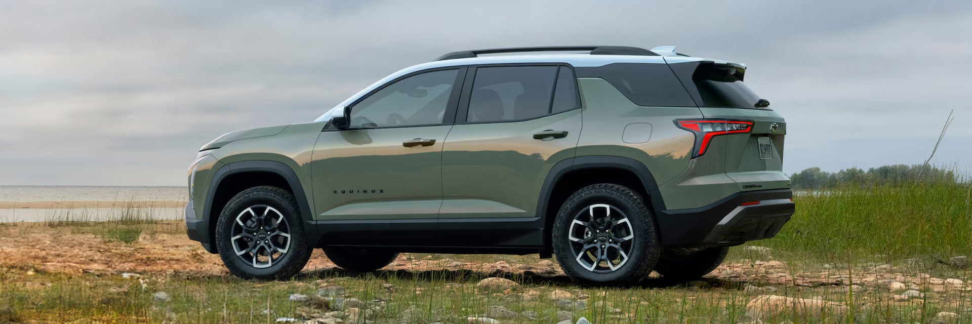 A green suv sitting parked in a field.