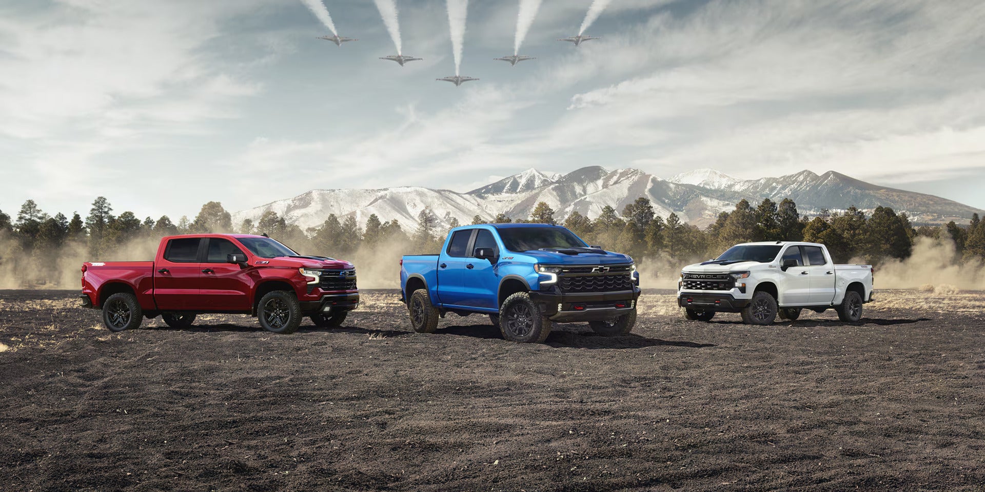 lineup of 2026 chevy silverado 1500s parked overlooking snowcapped mountains