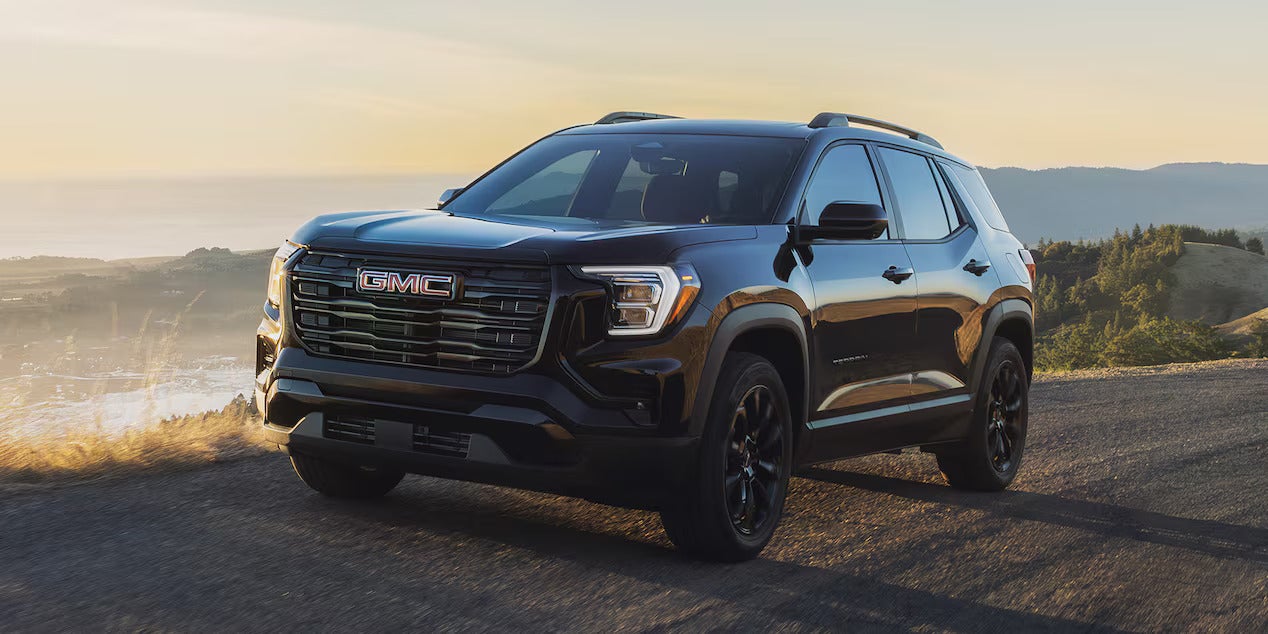 a black 2026 gmc terrain driving on a dirt path