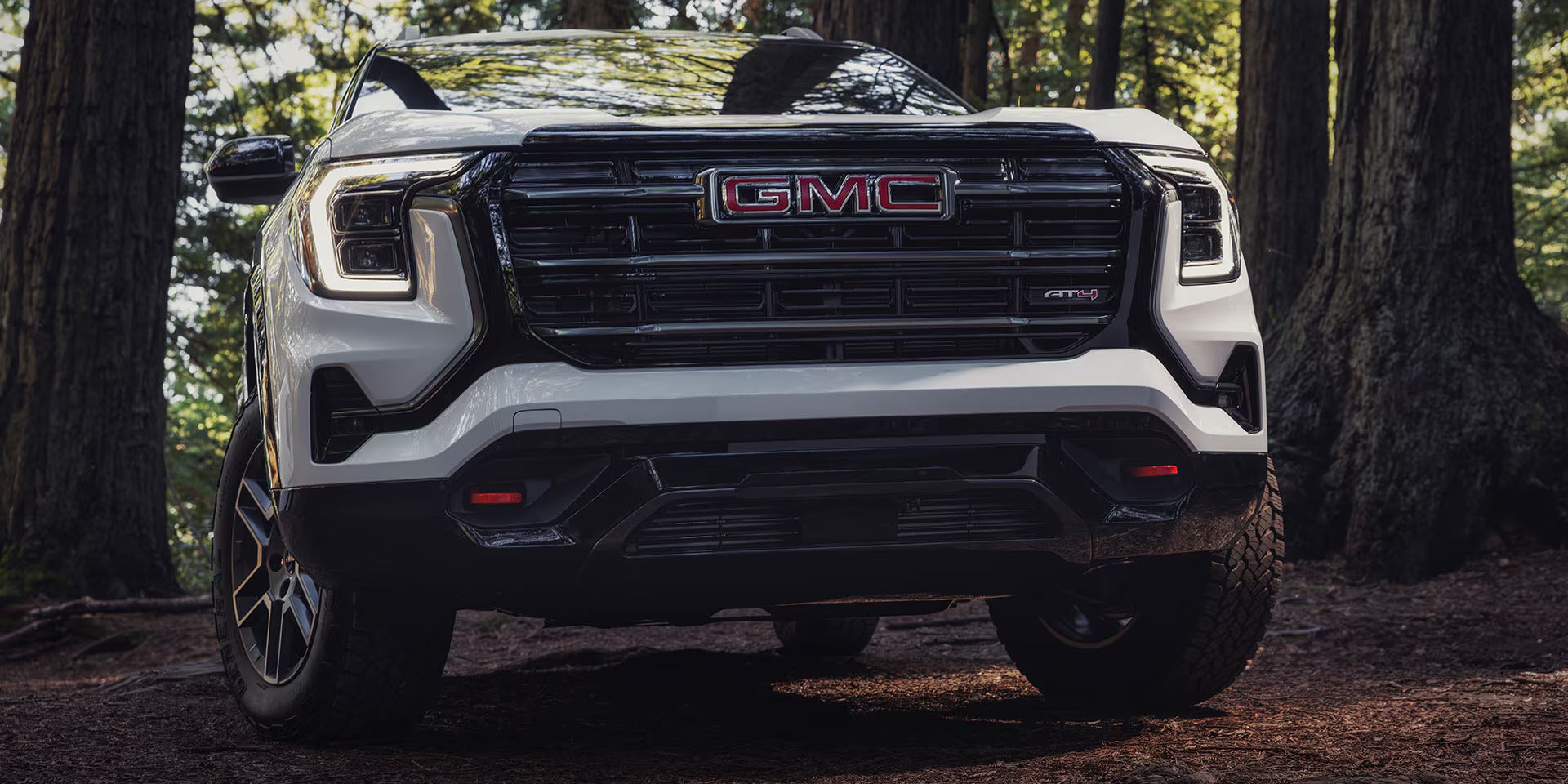 a white gmc terrain driving in the woods