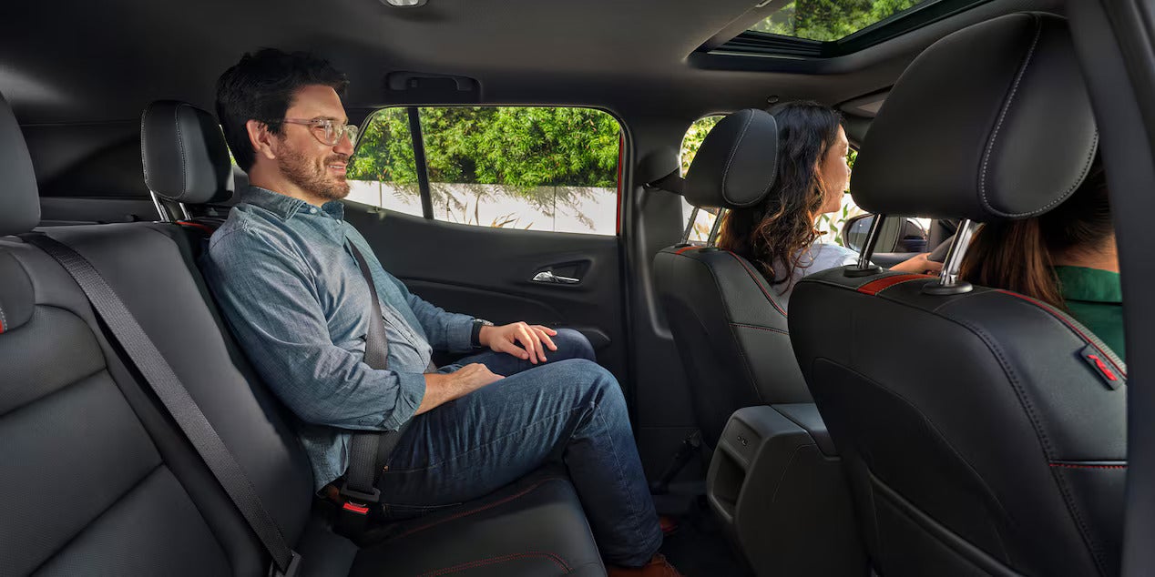 a man sitting in the back seat of a 2026 chevy trax