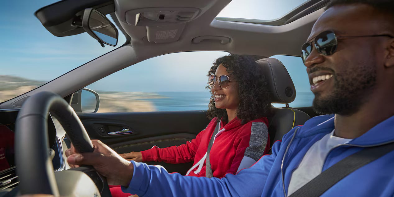 two people inside the 2026 chevy trax with the sunroof open