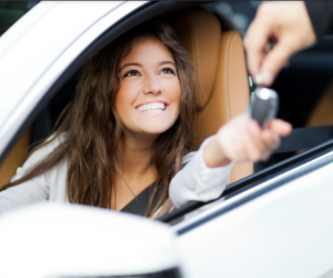 a woman receiving a key inside a car