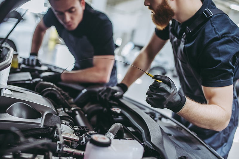 two mechanics working on a vehicle